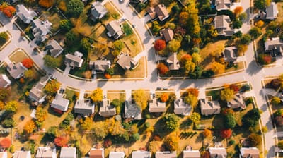 Illustrative stock photograph: Overhead view of homes, curving streets and autumn trees in a residential neighborhood.